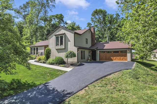 680 Rainbow Dr NW, Lancaster, OH 43130 - view of front of home with driveway, an attached garage, a chimney, a front yard, and roof with shingles