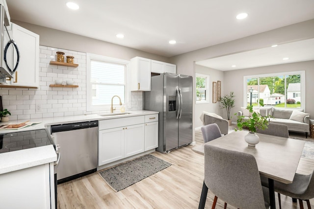 3432 Walmar Dr, Columbus, OH 43224 - kitchen with appliances with stainless steel finishes, light countertops, recessed lighting, backsplash, and white cabinetry