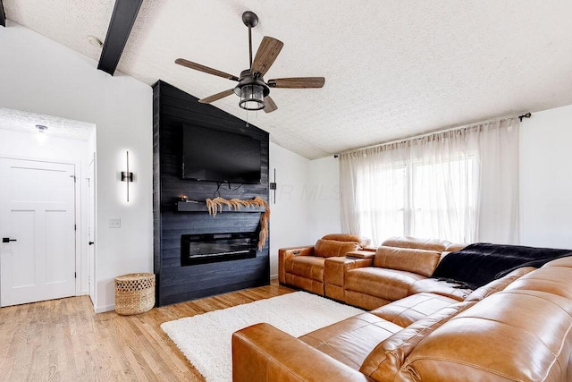 9710 Butcher Rd, Mount Vernon, OH 43050 - living room with vaulted ceiling, a textured ceiling, a large fireplace, ceiling fan, and light wood-style flooring