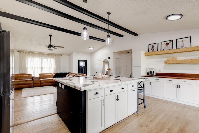 9710 Butcher Rd, Mount Vernon, OH 43050 - kitchen featuring light wood-type flooring, white cabinetry, hanging light fixtures, freestanding refrigerator, and ceiling fan