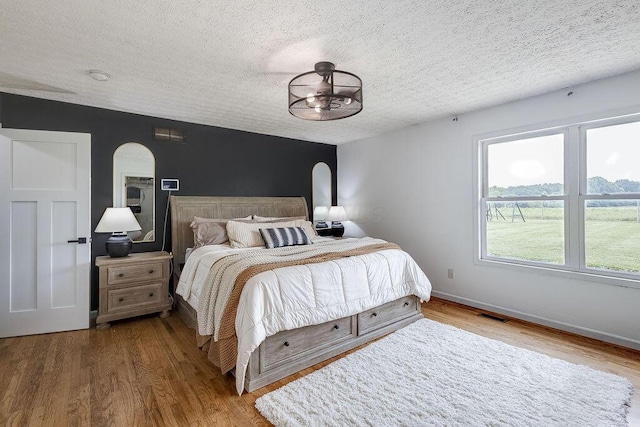 9710 Butcher Rd, Mount Vernon, OH 43050 - bedroom with arched walkways, a textured ceiling, and wood finished floors