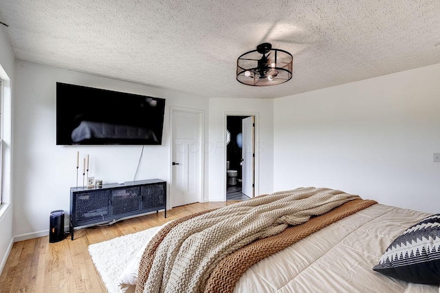 9710 Butcher Rd, Mount Vernon, OH 43050 - bedroom with wood finished floors, a textured ceiling, and a chandelier