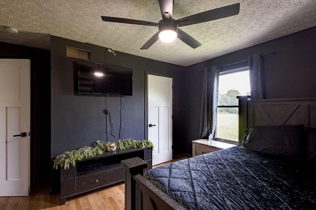 9710 Butcher Rd, Mount Vernon, OH 43050 - bedroom featuring a textured ceiling, light wood-style flooring, and ceiling fan