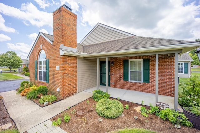 594 Chardonnay Ln, Lewis Center, OH 43035 - view of front of property featuring brick siding, a shingled roof, a chimney, and covered porch
