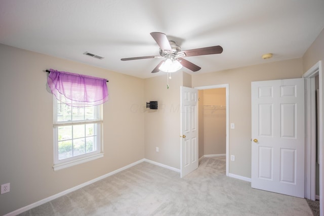 594 Chardonnay Ln, Lewis Center, OH 43035 - unfurnished bedroom featuring light carpet, a spacious closet, and ceiling fan