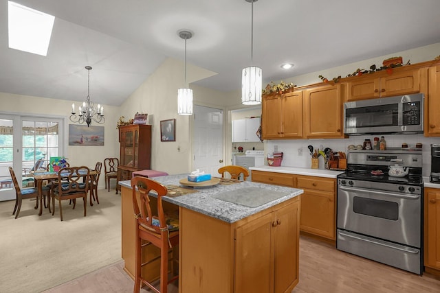 8421 Ransom Rd, Mount Vernon, OH 43050 - kitchen featuring appliances with stainless steel finishes, a chandelier, a skylight, a kitchen island, and washing machine and dryer