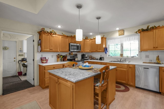 8421 Ransom Rd, Mount Vernon, OH 43050 - kitchen featuring appliances with stainless steel finishes, light wood-style floors, light countertops, a center island, and pendant lighting