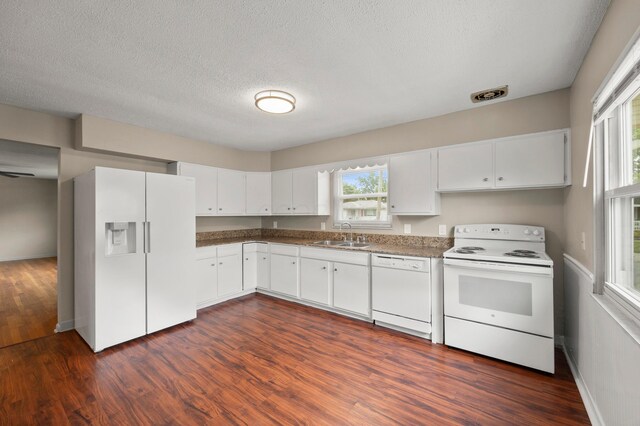 2468 Spaatz Ave, Columbus, OH 43204 - kitchen featuring white appliances, dark wood-type flooring, white cabinetry, and a textured ceiling