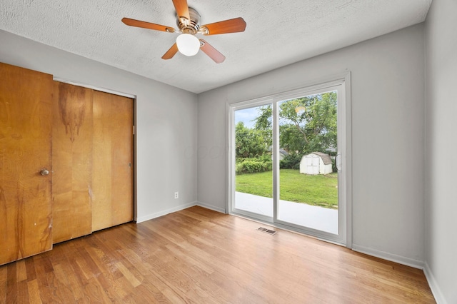 2468 Spaatz Ave, Columbus, OH 43204 - unfurnished bedroom featuring access to exterior, wood finished floors, a textured ceiling, a closet, and a ceiling fan