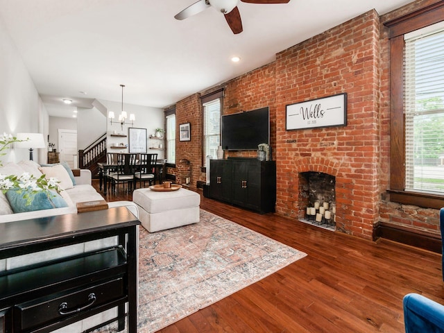 119 Miami Ave Unit 119, Columbus, OH 43203 - living room with a chandelier, a ceiling fan, wood finished floors, and a brick fireplace