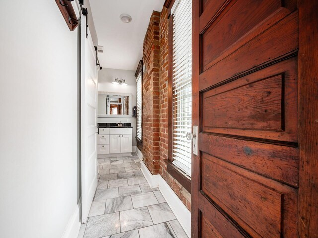 119 Miami Ave Unit 119, Columbus, OH 43203 - corridor with brick wall, a barn door, and light marble finish floors