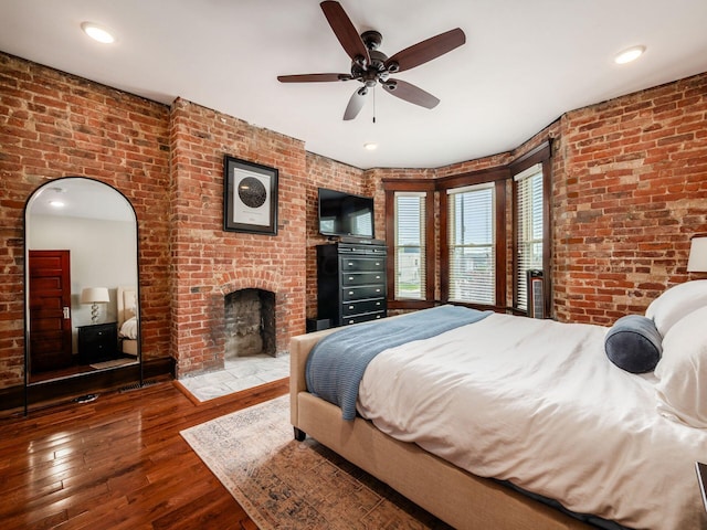 119 Miami Ave Unit 119, Columbus, OH 43203 - bedroom with brick wall, hardwood / wood-style floors, a fireplace, and a ceiling fan