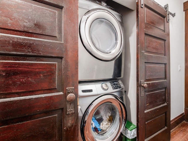 119 Miami Ave Unit 119, Columbus, OH 43203 - washroom featuring stacked washer / drying machine, wood finished floors, and a barn door