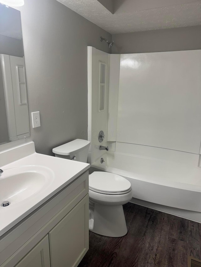 7771 Deercrest Ct, Dublin, OH 43016 - full bathroom with vanity, wood finished floors, bathing tub / shower combination, and a textured ceiling