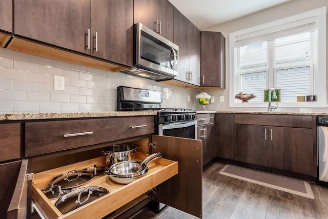 1232 N Grant Ave, Columbus, OH 43201 - kitchen featuring appliances with stainless steel finishes, dark wood-type flooring, dark brown cabinetry, and decorative backsplash