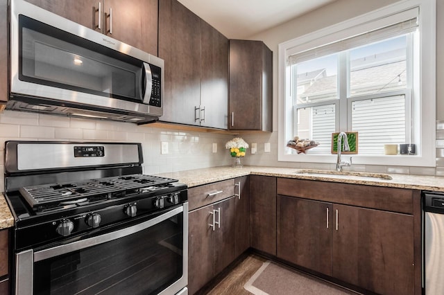 1232 N Grant Ave, Columbus, OH 43201 - kitchen with appliances with stainless steel finishes, dark brown cabinetry, and tasteful backsplash