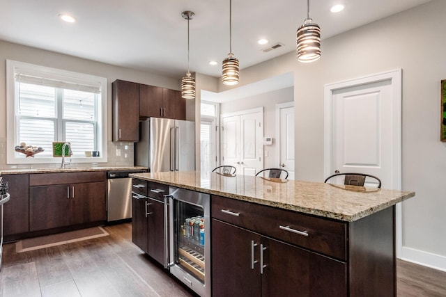 1232 N Grant Ave, Columbus, OH 43201 - kitchen featuring stainless steel appliances, beverage cooler, dark wood finished floors, dark brown cabinetry, and a kitchen island