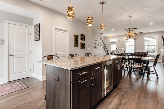 1232 N Grant Ave, Columbus, OH 43201 - kitchen with beverage cooler, dark wood finished floors, a breakfast bar area, pendant lighting, and recessed lighting