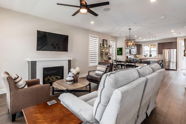 1232 N Grant Ave, Columbus, OH 43201 - living room with recessed lighting, a ceiling fan, wood finished floors, a chandelier, and a glass covered fireplace