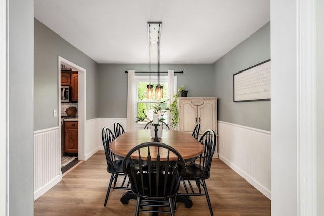 2566 Mcdaniel Ct, Grove City, OH 43123 - dining space featuring a wainscoted wall, wood finished floors, and a chandelier
