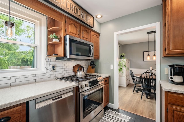 2566 Mcdaniel Ct, Grove City, OH 43123 - kitchen with appliances with stainless steel finishes, brown cabinets, decorative backsplash, open shelves, and hanging light fixtures
