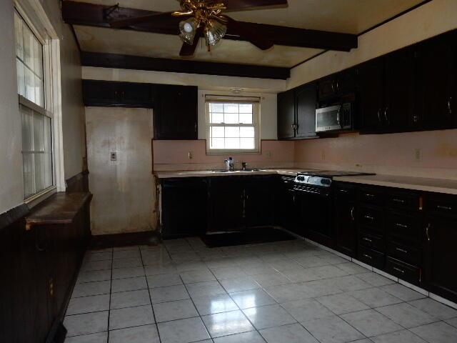 1549 Alpine Dr, Columbus, OH 43229 - kitchen featuring stainless steel microwave, dark cabinets, range, and beamed ceiling