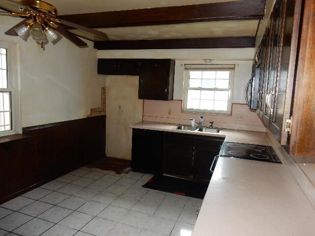 1549 Alpine Dr, Columbus, OH 43229 - kitchen with light countertops, beamed ceiling, ceiling fan, and stove