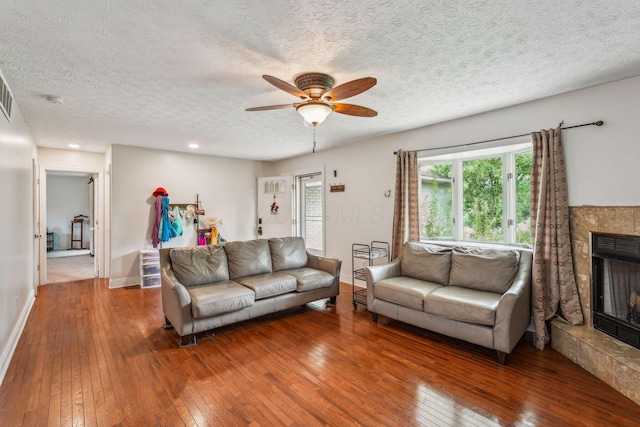 9900 Waterloo Eastern Rd, Canal Winchester, OH 43110 - living room with hardwood / wood-style flooring, a ceiling fan, a fireplace with raised hearth, and a textured ceiling