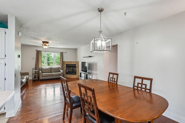 9900 Waterloo Eastern Rd, Canal Winchester, OH 43110 - dining room with a fireplace, dark wood-style floors, a chandelier, a textured ceiling, and a ceiling fan