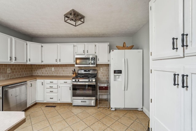 9900 Waterloo Eastern Rd, Canal Winchester, OH 43110 - kitchen with appliances with stainless steel finishes, white cabinets, tasteful backsplash, and a textured ceiling