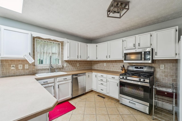 9900 Waterloo Eastern Rd, Canal Winchester, OH 43110 - kitchen with stainless steel appliances, light countertops, decorative backsplash, white cabinets, and a textured ceiling