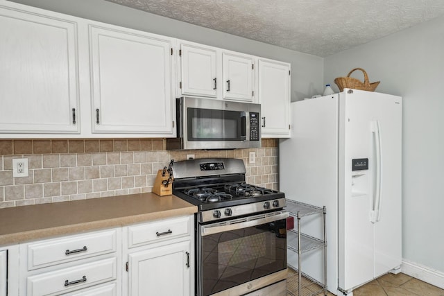 9900 Waterloo Eastern Rd, Canal Winchester, OH 43110 - kitchen featuring stainless steel appliances, white cabinetry, decorative backsplash, and light tile patterned flooring
