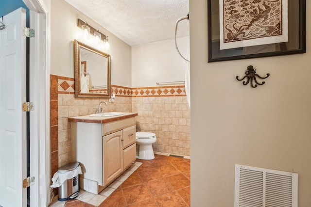 9900 Waterloo Eastern Rd, Canal Winchester, OH 43110 - bathroom featuring tile walls, vanity, a textured ceiling, tile patterned floors, and wainscoting