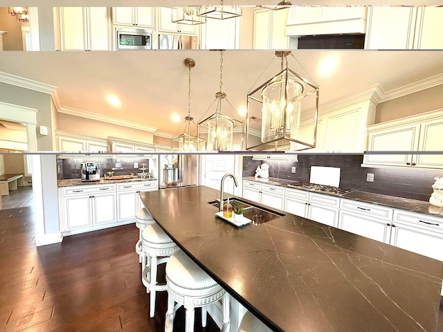 2000 Forestview Ln, Delaware, OH 43015 - kitchen with appliances with stainless steel finishes, a chandelier, crown molding, dark countertops, and decorative backsplash
