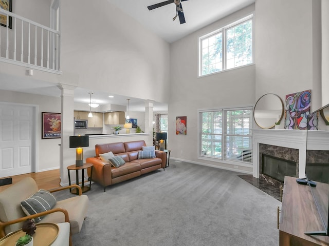 1235 Shagbark Rd, Columbus, OH 43230 - carpeted living area with ornate columns, ceiling fan, a high ceiling, and a premium fireplace