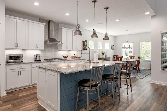 5540 Eva Loop S, Dublin, OH 43016 - kitchen with wall chimney exhaust hood, recessed lighting, tasteful backsplash, dark wood-style floors, and white cabinetry