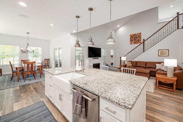 5540 Eva Loop S, Dublin, OH 43016 - kitchen with stainless steel dishwasher, open floor plan, light wood finished floors, recessed lighting, and hanging light fixtures