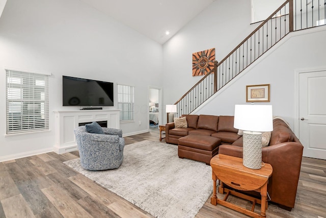 5540 Eva Loop S, Dublin, OH 43016 - living room with high vaulted ceiling, wood finished floors, stairway, a fireplace, and recessed lighting