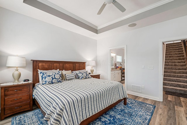 5540 Eva Loop S, Dublin, OH 43016 - bedroom featuring ornamental molding, light wood-style flooring, connected bathroom, ceiling fan, and a raised ceiling
