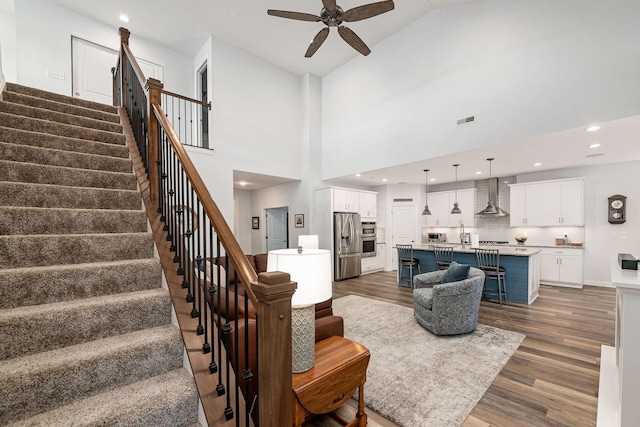 5540 Eva Loop S, Dublin, OH 43016 - living area with stairway, a ceiling fan, dark wood-style floors, recessed lighting, and a high ceiling