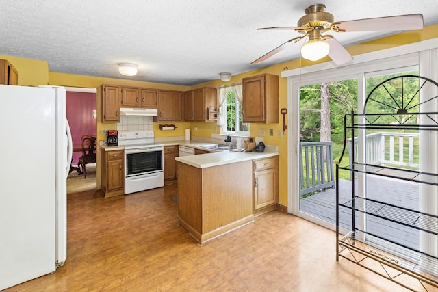 5500 Saddlebrook Dr, Columbus, OH 43221 - kitchen with white appliances, a peninsula, light wood-style flooring, under cabinet range hood, and a textured ceiling