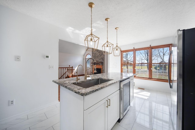 5583 Durrett Rd, Orient, OH 43146 - kitchen featuring freestanding refrigerator, a kitchen island with sink, stone countertops, white cabinets, and wine cooler