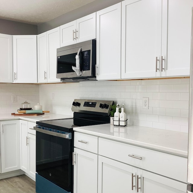 652 E 6th Ave, Lancaster, OH 43130 - kitchen with appliances with stainless steel finishes, light countertops, white cabinets, and a textured ceiling