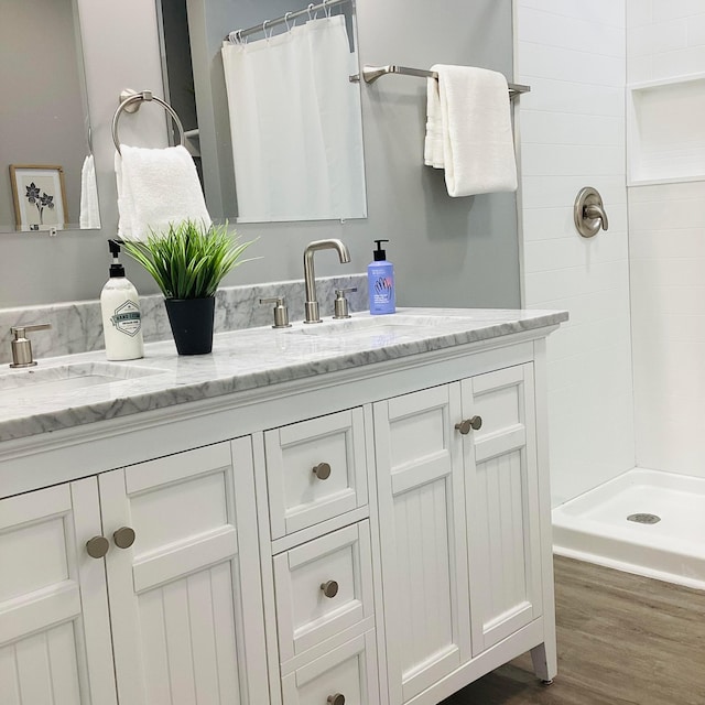 652 E 6th Ave, Lancaster, OH 43130 - full bath featuring double vanity, tiled shower, and wood finished floors
