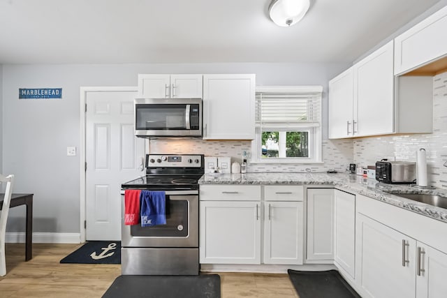 2931 Templeton Rd, Columbus, OH 43209 - kitchen with stainless steel appliances, light wood-style floors, and tasteful backsplash
