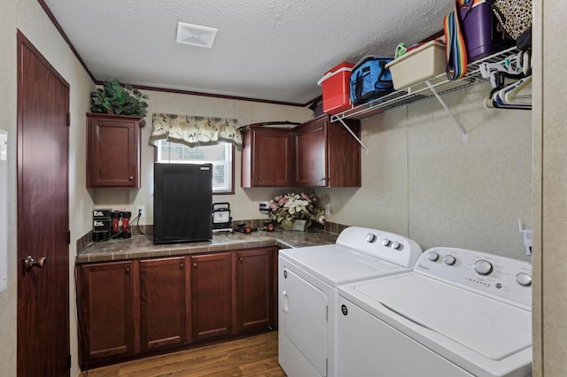2445 Columbus-Lancaster Rd NW Unit 248Hickory, Lancaster, OH 43130 - laundry area featuring washing machine and dryer, cabinet space, wood finished floors, a textured ceiling, and ornamental molding