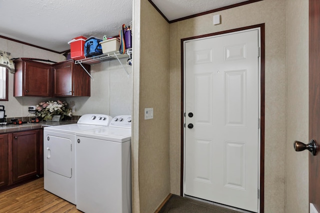 2445 Columbus-Lancaster Rd NW Unit 248Hickory, Lancaster, OH 43130 - washroom with cabinet space, washer and dryer, crown molding, a textured ceiling, and light wood-style floors