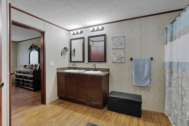2445 Columbus-Lancaster Rd NW Unit 248Hickory, Lancaster, OH 43130 - bathroom featuring ornamental molding, wood finished floors, double vanity, a textured ceiling, and curtained shower