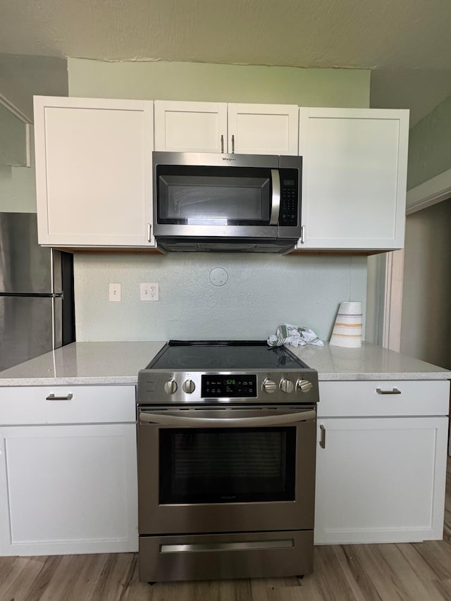 1345 E Livingston Ave Unit 1347, Columbus, OH 43205 - kitchen with stainless steel appliances, light wood-style flooring, and white cabinetry