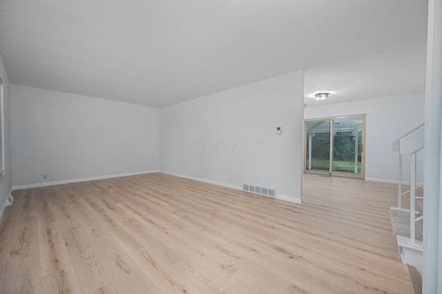 260 Old Coach Pl, Canal Winchester, OH 43110 - unfurnished living room with light wood finished floors, stairs, and a textured ceiling